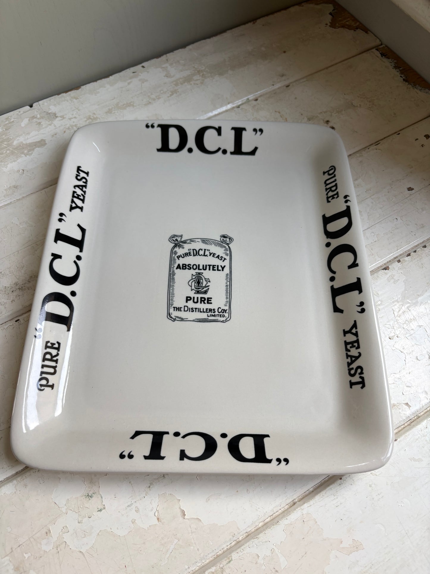 Early 20th century English ironstone DCL Yeast advertising shop counter display plate with black typography graphics.
