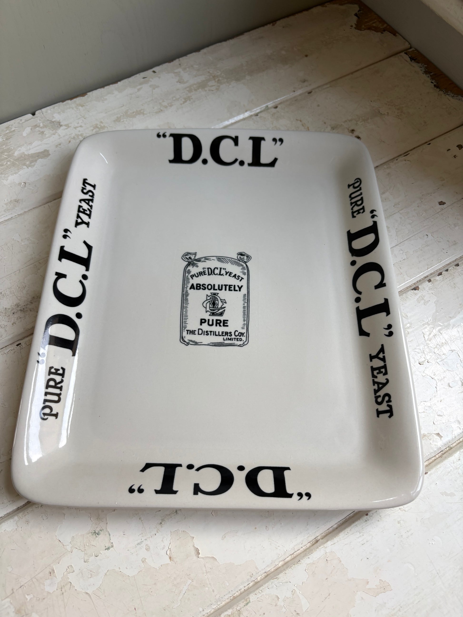 Early 20th century English ironstone DCL Yeast advertising shop counter display plate with black typography graphics.