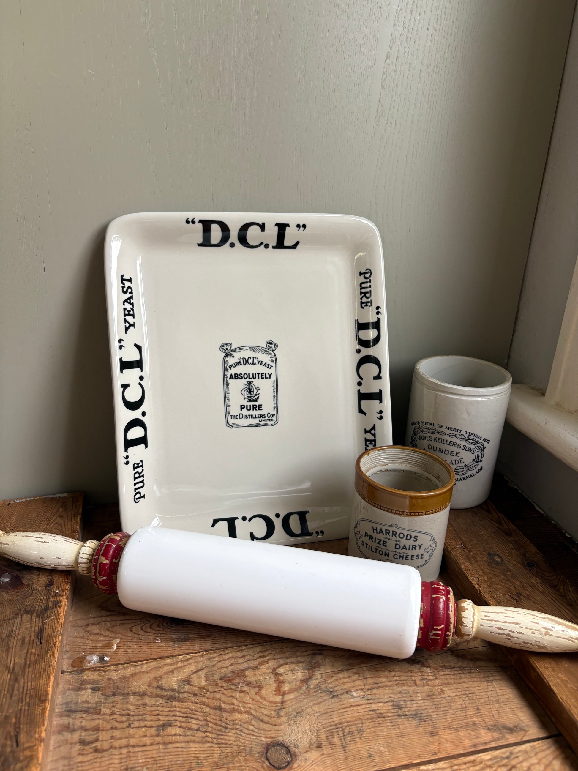 Wide angle view of antique white ceramic rolling pin styled with other objects  