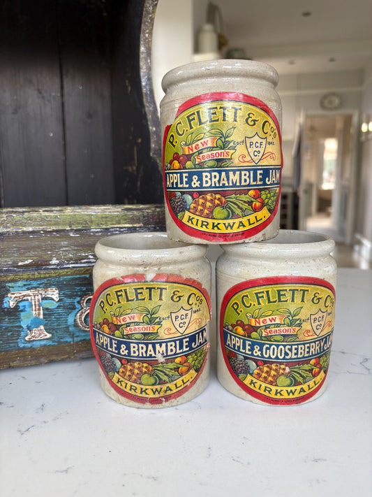 A vintage shop display for jam with five stone pots.